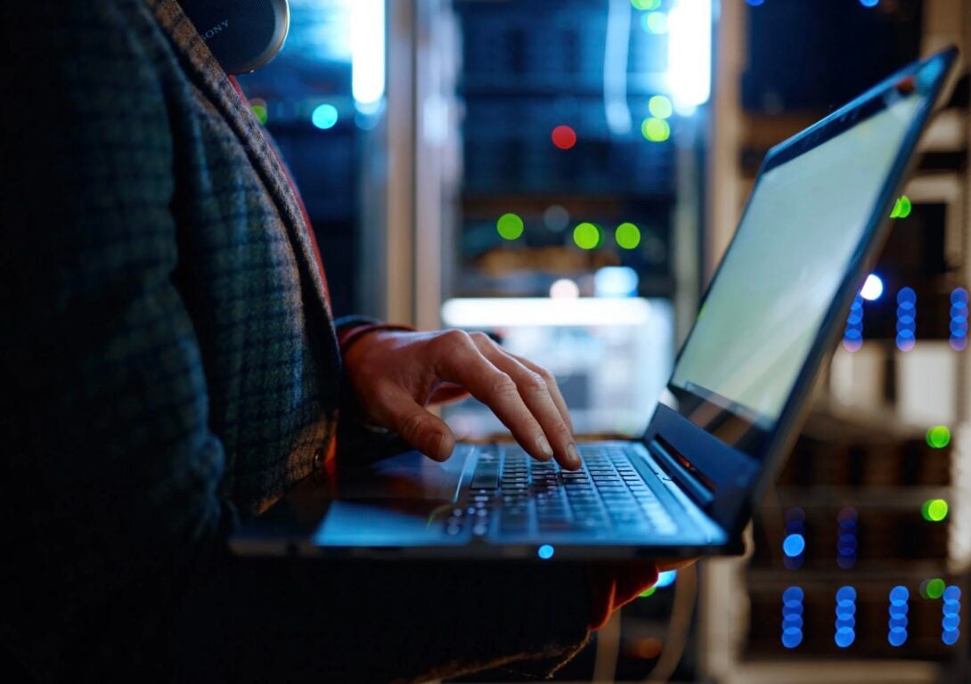 Man using laptop in server room